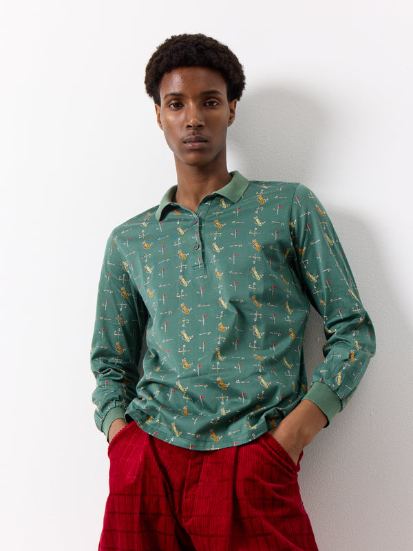 This Christian Dior shirt features illustrated golf club designs on a vintage sports shirt. It has a half button and polo shirt style and long sleeves.