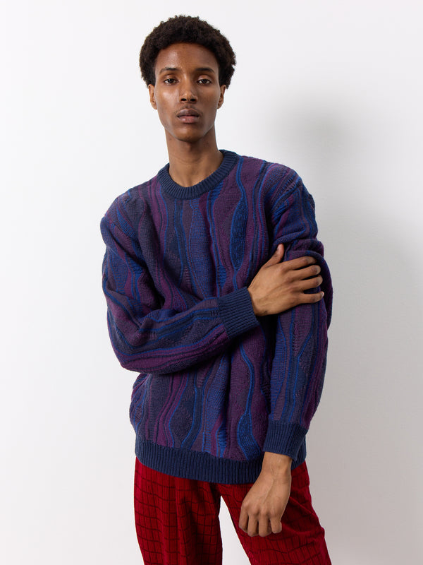 Elevate your style with this one-of-a-kind purple knit wool sweater. The rich purple and blue pattern adds a unique touch to the thick wool design, making it a standout piece in your wardrobe.