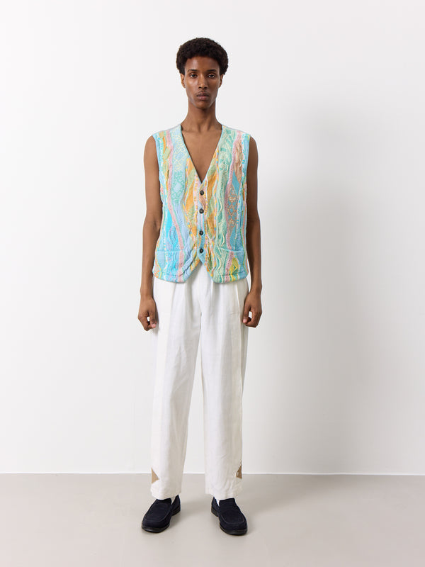 Elevate your wardrobe with this unique Coogi vest waistcoat in a rare pastel blue shade. The light gray satin back and tie back add a touch of sophistication, while the four button closure and front pockets provide both style and functionality. This vest features the original Coogi design, making it a must-have for vintage lovers.