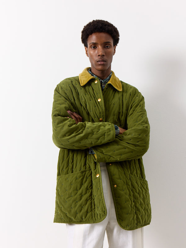 The ultimate field jacket. This Hermes green quilted field jacket features a beautiful vintage design, with a snap button front and multiple pockets including a secret inner pocket. The coat is further accented by a corduroy collar and gold button logo signage.