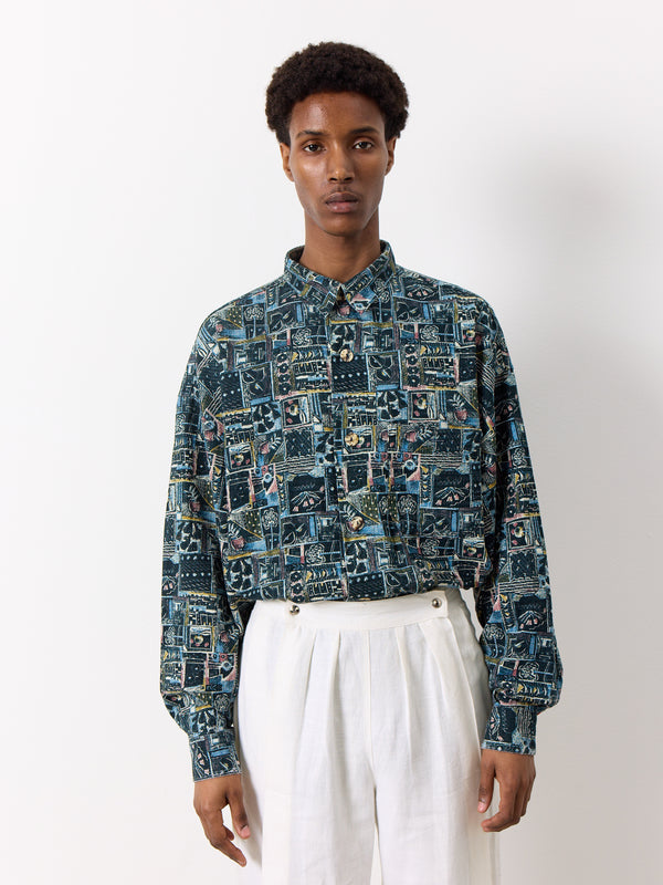 This black vintage shirt for men features a striking print, classic collar, long sleeves, and button front. Notably, the elbow pads are adorned with a distinctive camo design.