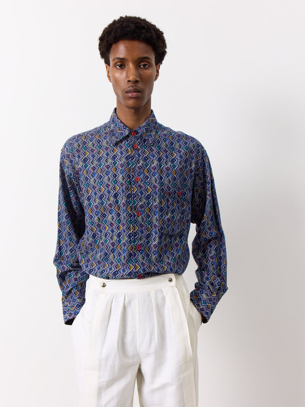 This vintage Missoni shirt features a dark blue color with a unique purple and white geometric print. With a front pocket and a long collared design, this shirt is perfect for any fashion-forward individual.