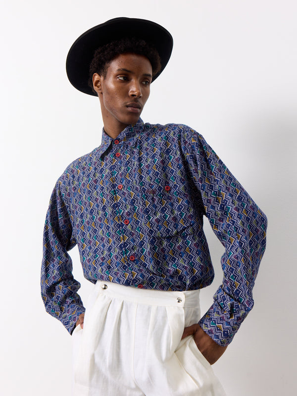 This vintage Missoni shirt features a dark blue color with a unique purple and white geometric print. With a front pocket and a long collared design, this shirt is perfect for any fashion-forward individual.