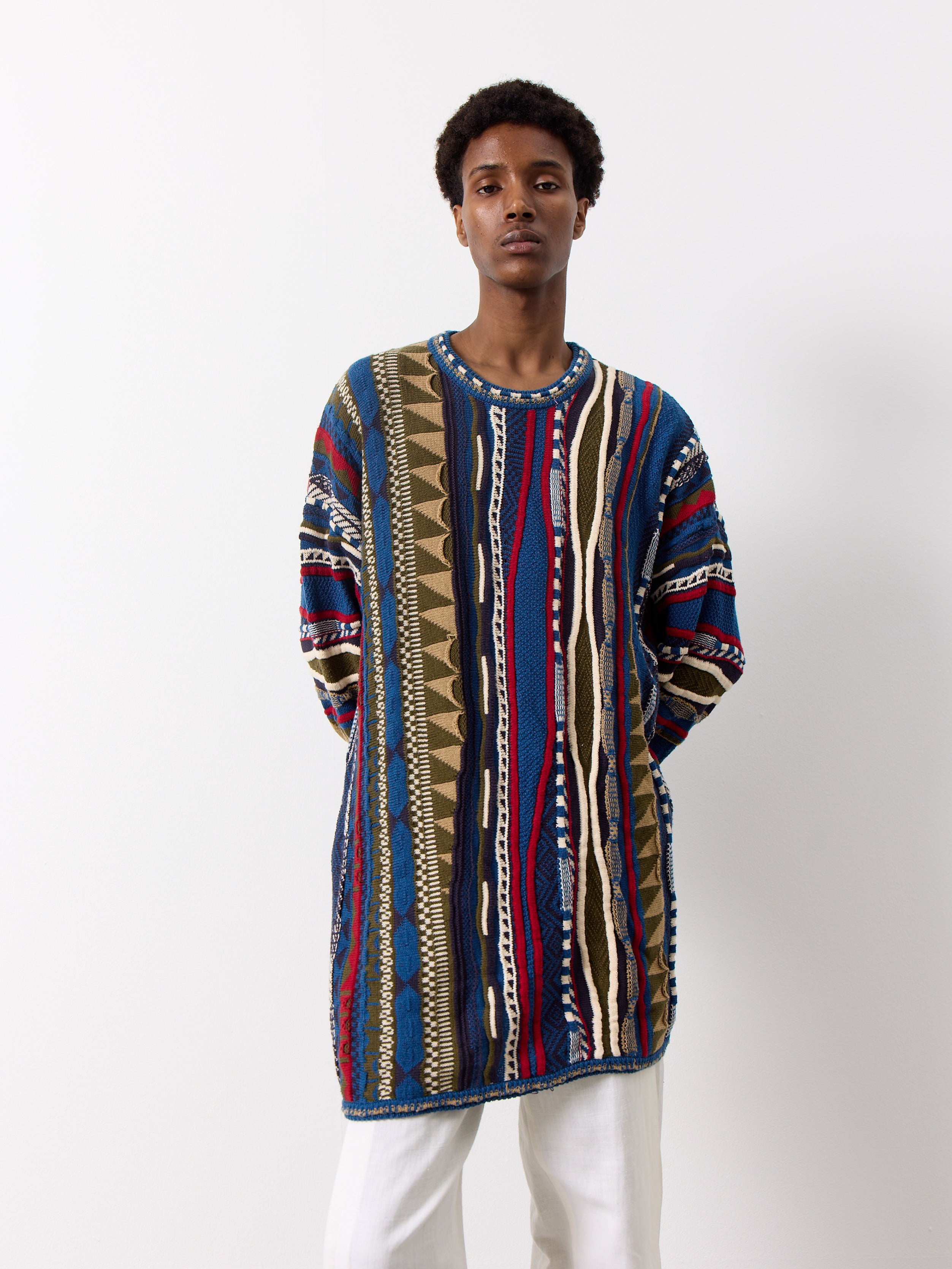 This three dimensional vintage knit sweater is uniquely inspired by Coogi, showcasing a bold design and vibrant colors.