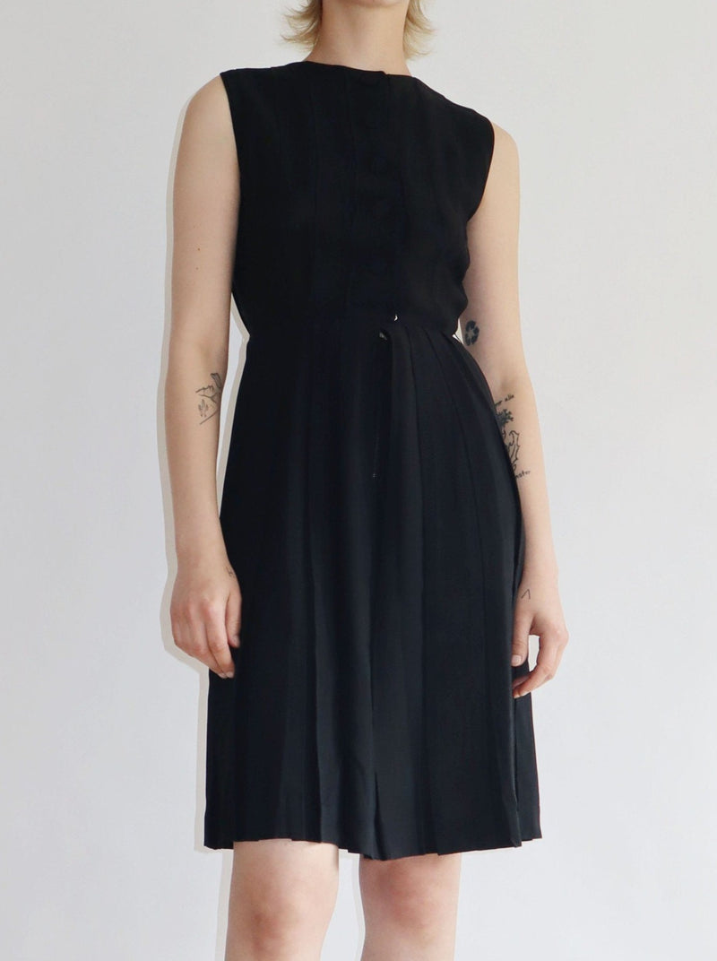 Vintage cute chic 60s sheer black dress with a button front and zip. Pleated skirt, in a slim fit.
