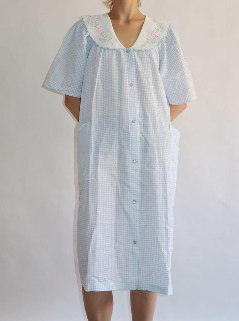 Lovely deadstock night robe dress with embroidered collar in pastel tones. Snap button front with pockets in an oversized fit. Soft gingham style blue checked cotton.