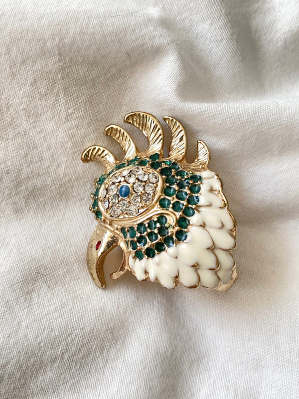 This beautiful golden-hued ring, crafted by renowned designer Betsey Johnson, features a large bird motif. With a sturdy construction and painted enamel with crystal detailing, this piece is a must-have for any collection.